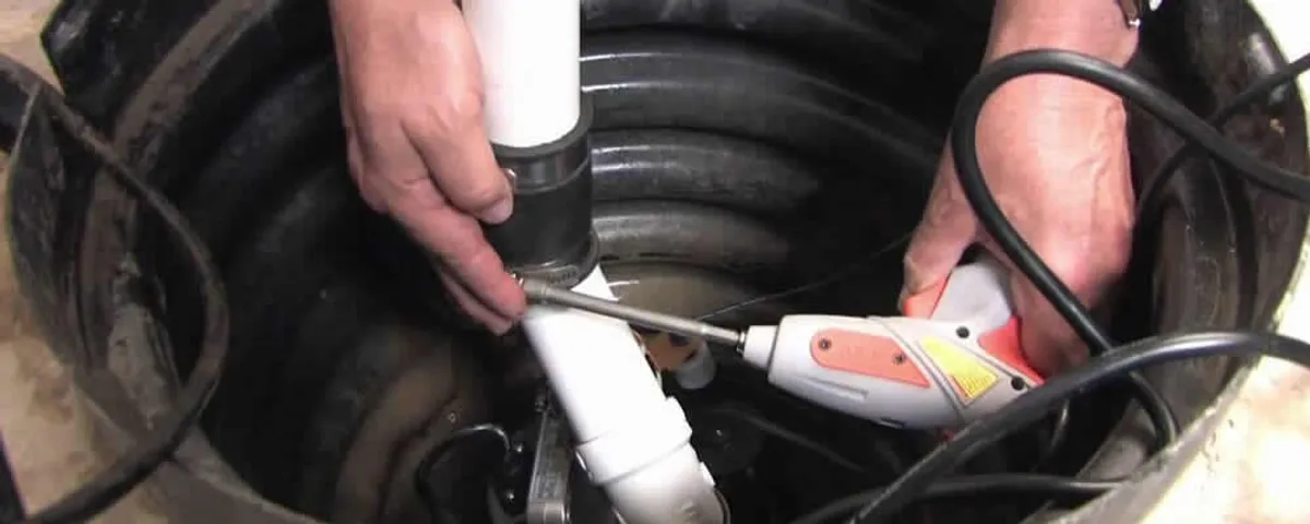 Sump pump installation technician connecting PVC discharge piping in Green Bay, WI